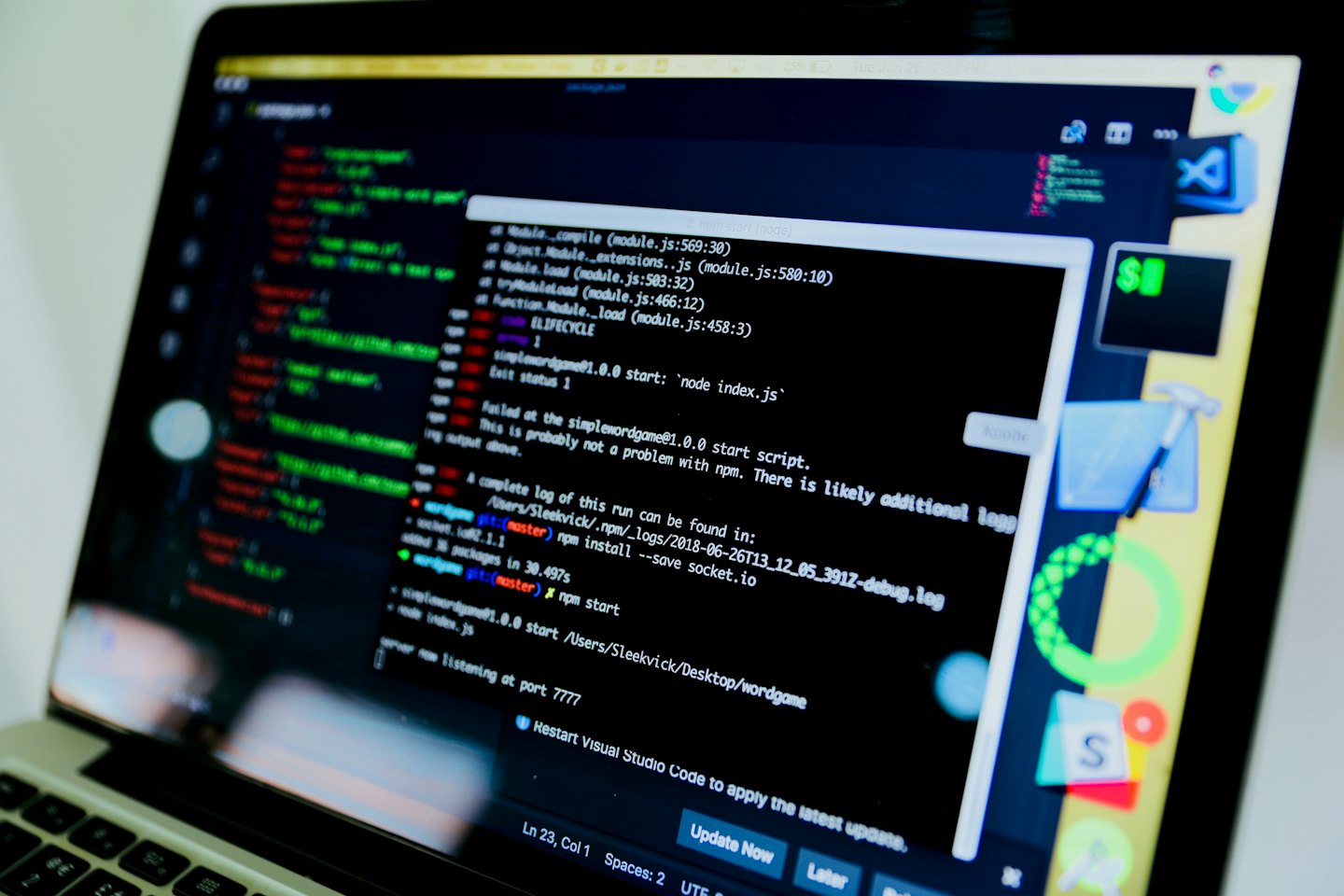 Laptop mit Code und Fehlermeldungen im Terminal beim Debuggen.