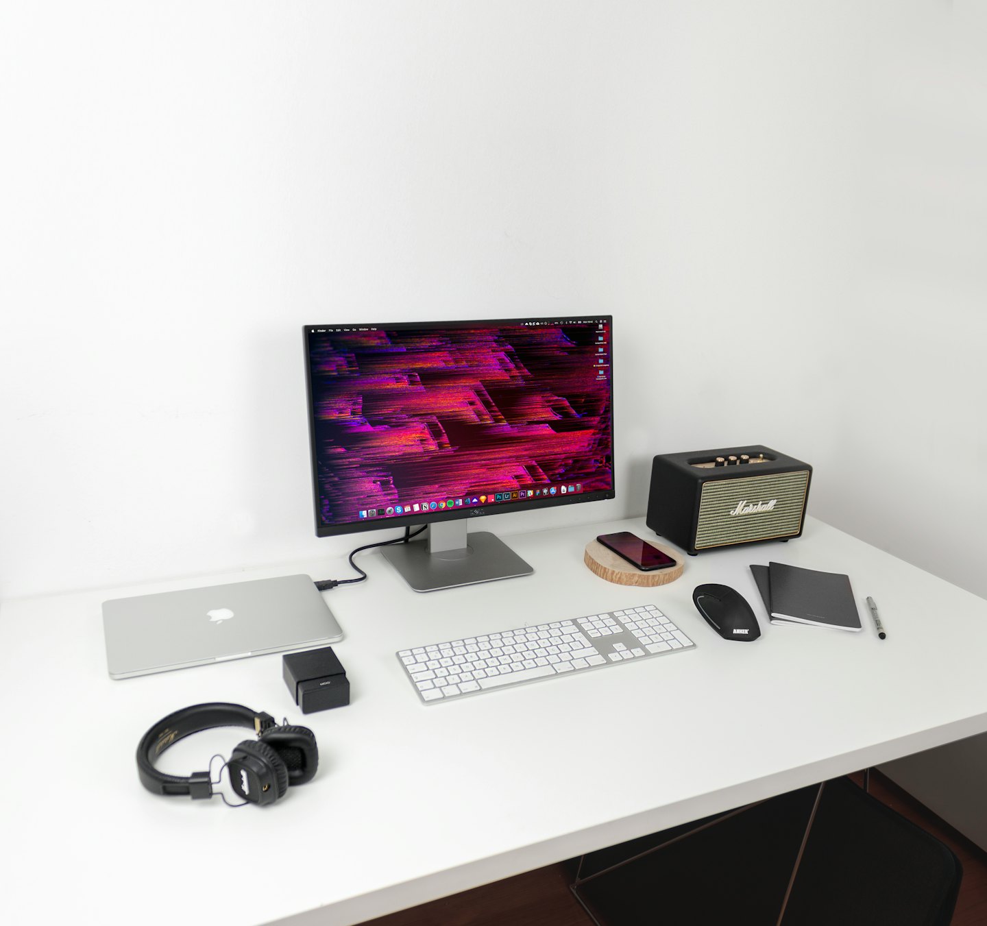 Moderner Computertisch mit Laptop und Monitor auf weißem Schreibtisch.